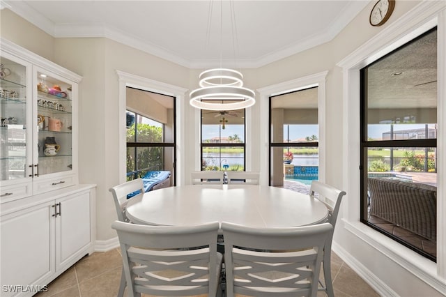 dining room featuring crown molding, light tile patterned floors, and a chandelier