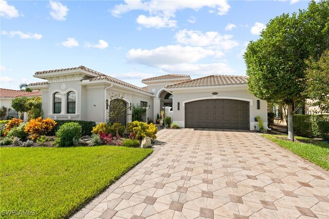 mediterranean / spanish-style home with a front lawn and a garage