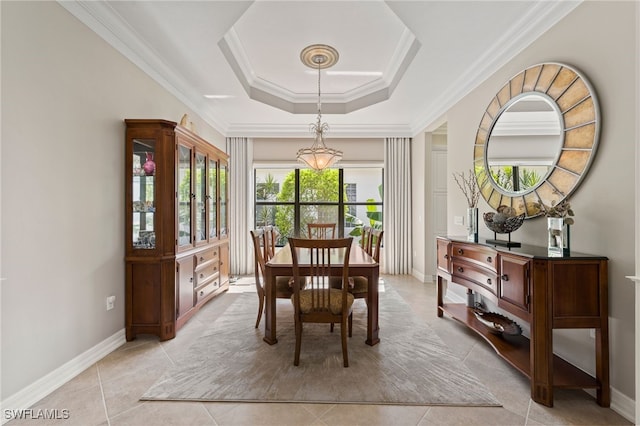 dining area featuring crown molding, light tile patterned flooring, and a tray ceiling