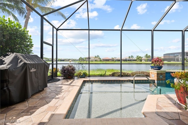 view of pool with a water view, a patio area, and glass enclosure