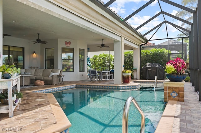 view of swimming pool featuring an outdoor living space, ceiling fan, a patio area, and glass enclosure