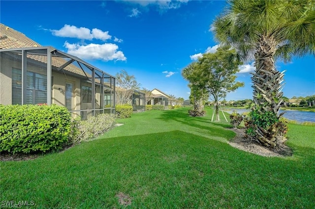 view of yard featuring a water view and glass enclosure