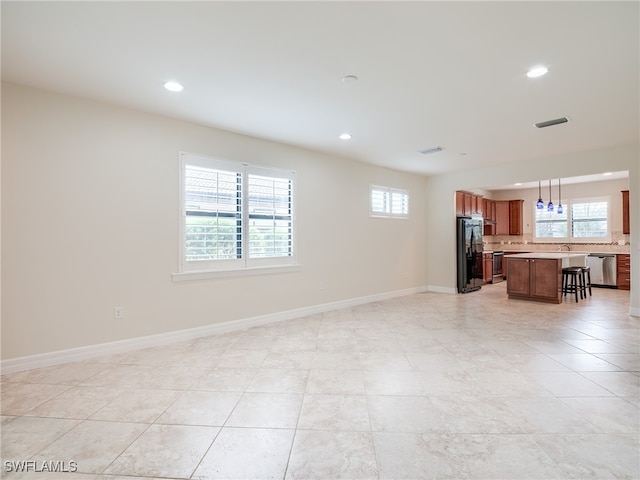 unfurnished living room featuring sink and light tile patterned floors