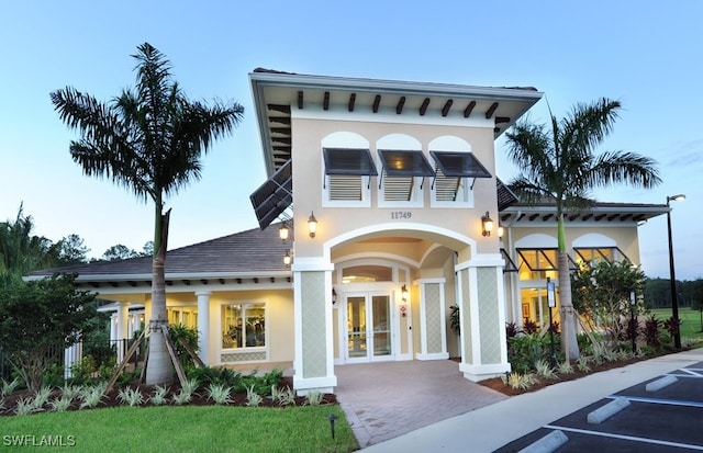 exterior space with french doors and a front lawn