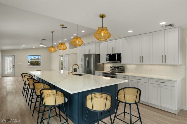 kitchen with hanging light fixtures, white cabinets, a spacious island, and stainless steel appliances