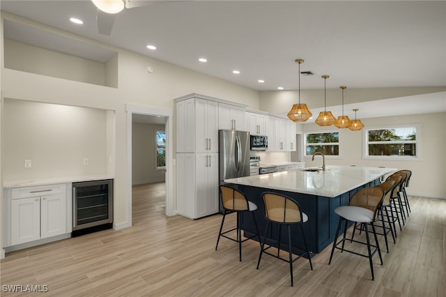 kitchen featuring wine cooler, visible vents, appliances with stainless steel finishes, light wood-style floors, and a sink