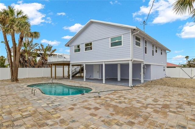 rear view of house with a swimming pool side deck and a patio