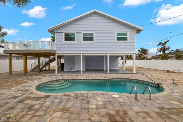 rear view of property with a swimming pool side deck and a patio area