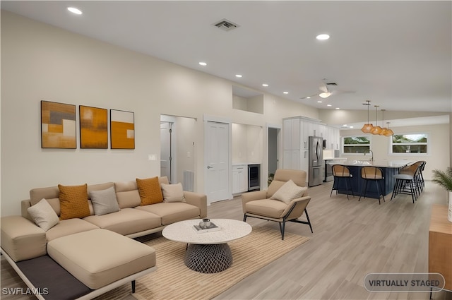 living area with light wood finished floors, beverage cooler, visible vents, and recessed lighting