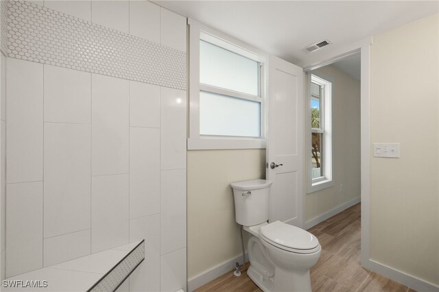 bathroom featuring plenty of natural light, wood-type flooring, and toilet