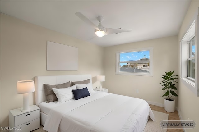 bedroom featuring light wood-type flooring, ceiling fan, and baseboards