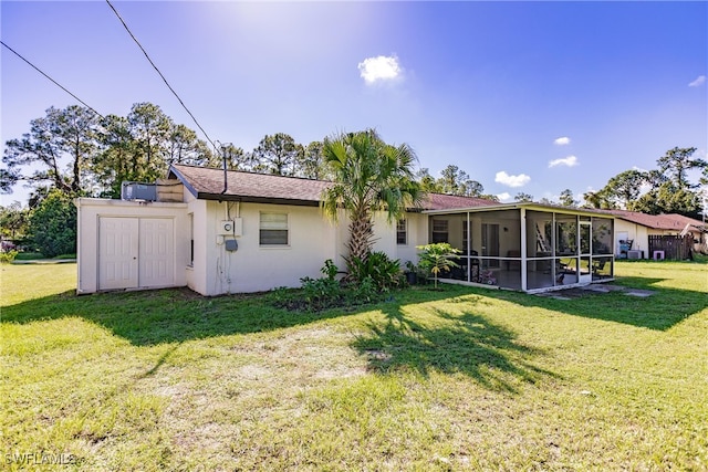 back of property featuring a lawn and a sunroom