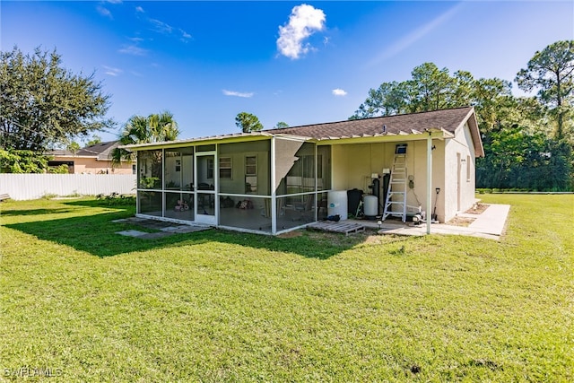 back of property featuring a sunroom and a lawn