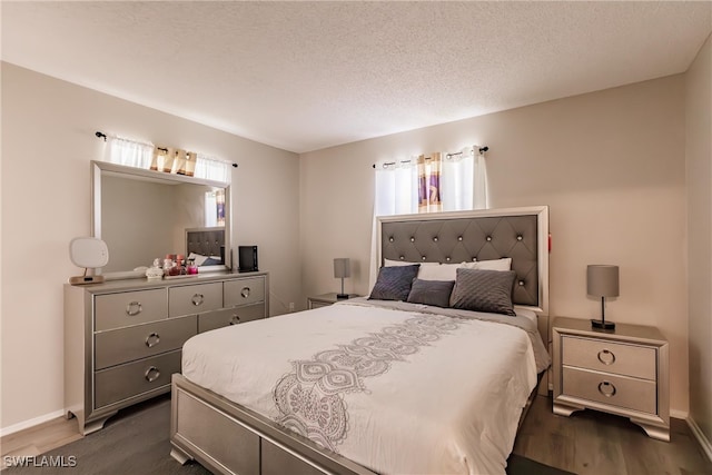 bedroom with a textured ceiling and dark hardwood / wood-style flooring