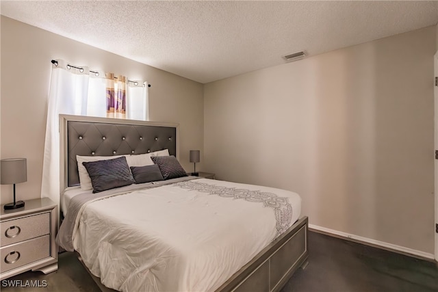 bedroom featuring a textured ceiling and dark colored carpet