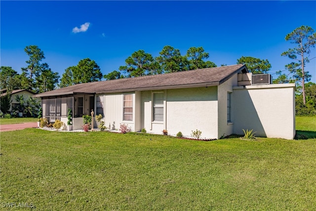 single story home featuring a sunroom and a front lawn