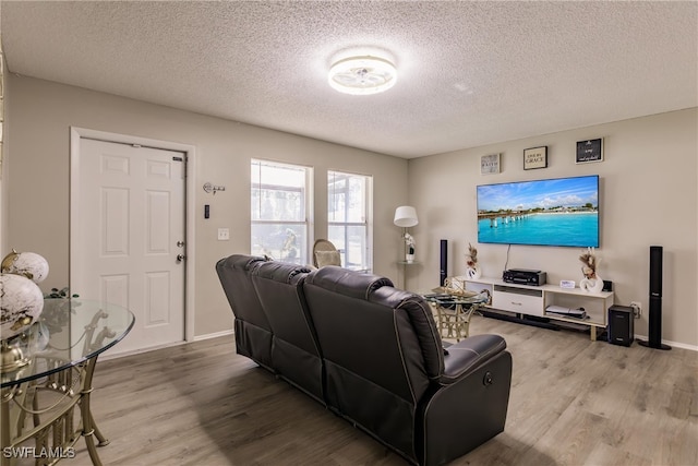 living room with light wood-type flooring and a textured ceiling