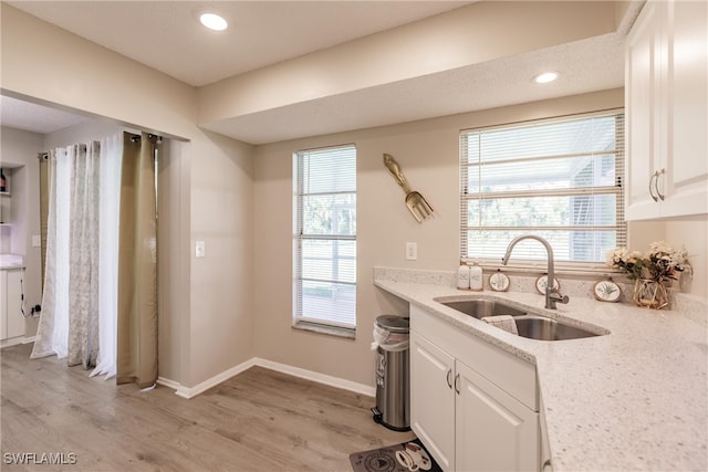 kitchen with white cabinets, sink, and light hardwood / wood-style floors