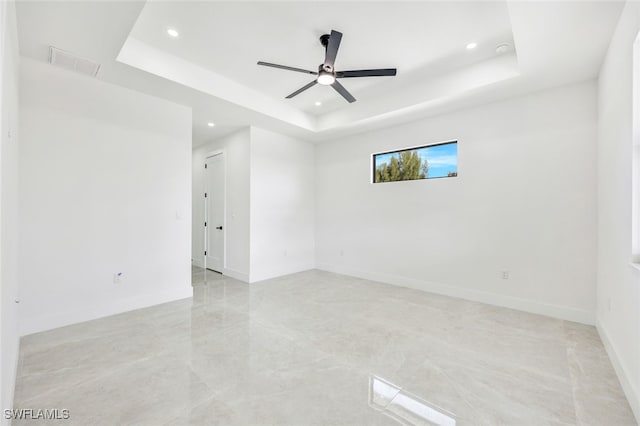 spare room featuring recessed lighting, a raised ceiling, visible vents, and baseboards