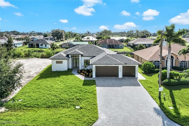 view of front of home featuring a garage, a front lawn, decorative driveway, and a residential view