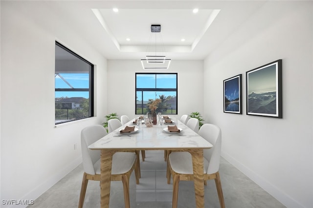 dining area with baseboards, a tray ceiling, and recessed lighting