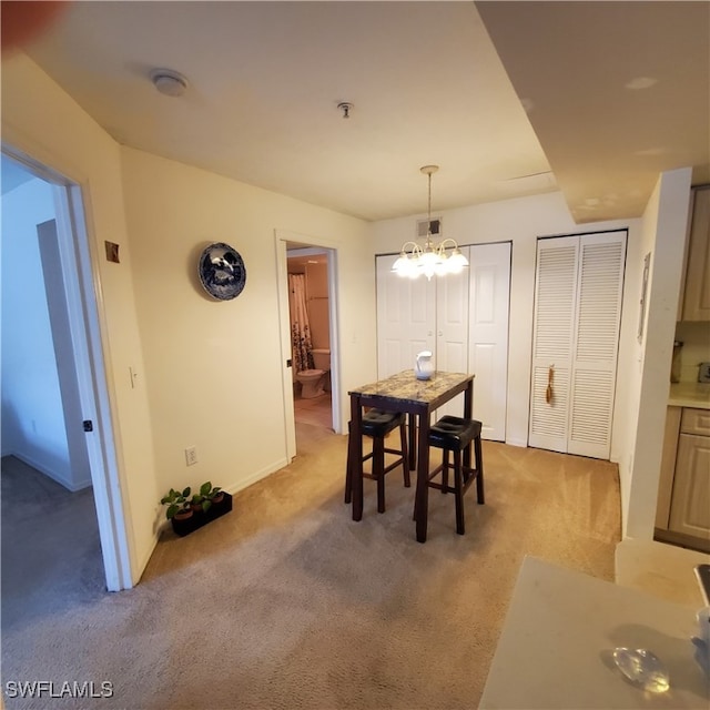 carpeted dining room with a chandelier