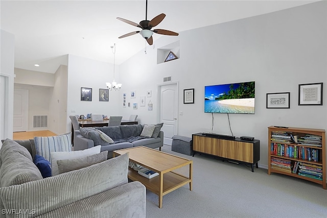 carpeted living room featuring ceiling fan with notable chandelier and high vaulted ceiling