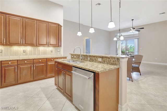 kitchen with ceiling fan with notable chandelier, sink, hanging light fixtures, stainless steel dishwasher, and light tile patterned floors