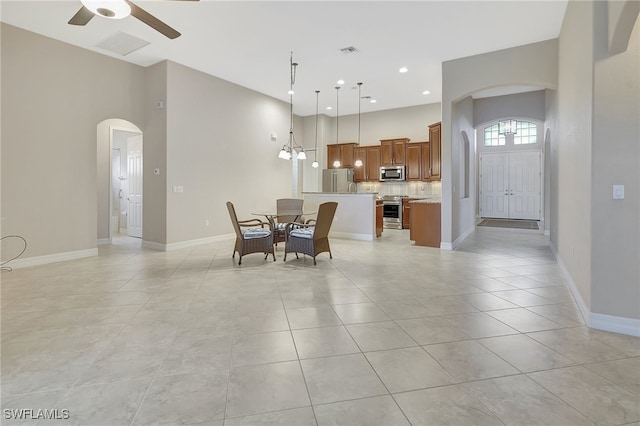 tiled dining room featuring ceiling fan with notable chandelier