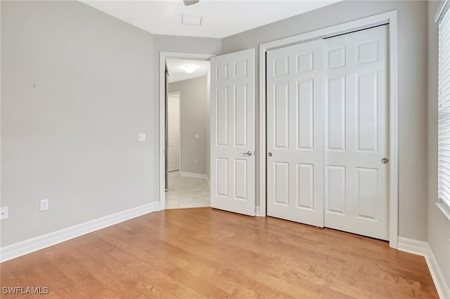 unfurnished bedroom featuring a closet and light hardwood / wood-style flooring