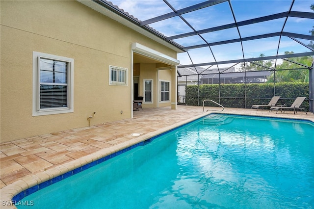 view of swimming pool with glass enclosure and a patio area