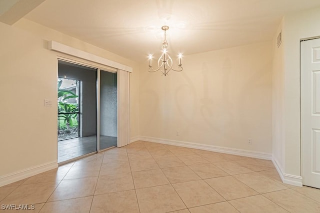 empty room with an inviting chandelier and light tile patterned floors