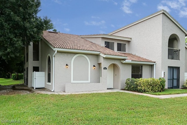 mediterranean / spanish-style home featuring a front yard