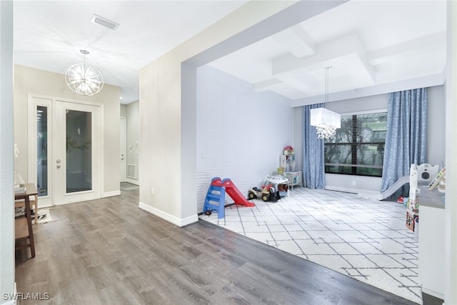 foyer entrance with beamed ceiling, a notable chandelier, and hardwood / wood-style flooring