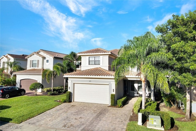 mediterranean / spanish-style house featuring a front yard and a garage