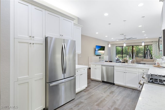 4119 Zelkova Ct, Naples, FL 34119 - kitchen with stainless steel appliances, a sink, ceiling fan, light wood-style floors, and white cabinets