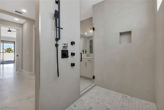 bathroom with ceiling fan, vanity, and a shower