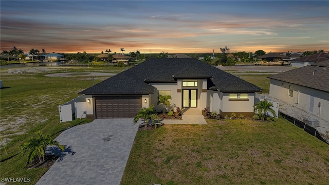 view of front of house featuring a lawn and a garage