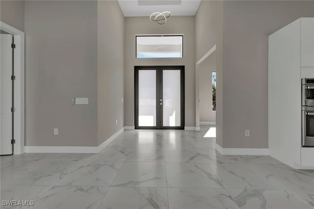 entryway with french doors and a towering ceiling