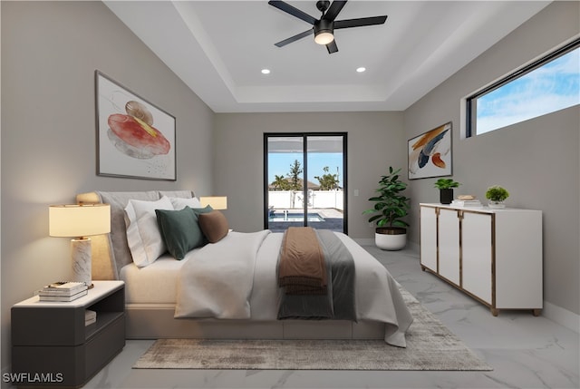 bedroom with multiple windows, a raised ceiling, access to exterior, and ceiling fan