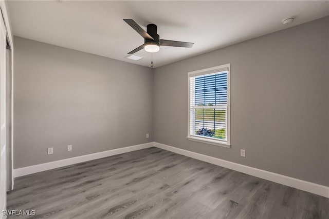 unfurnished room featuring wood finished floors, a ceiling fan, and baseboards