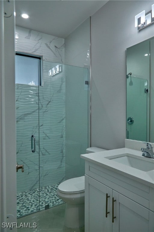 bathroom featuring vanity, toilet, and a shower with shower door