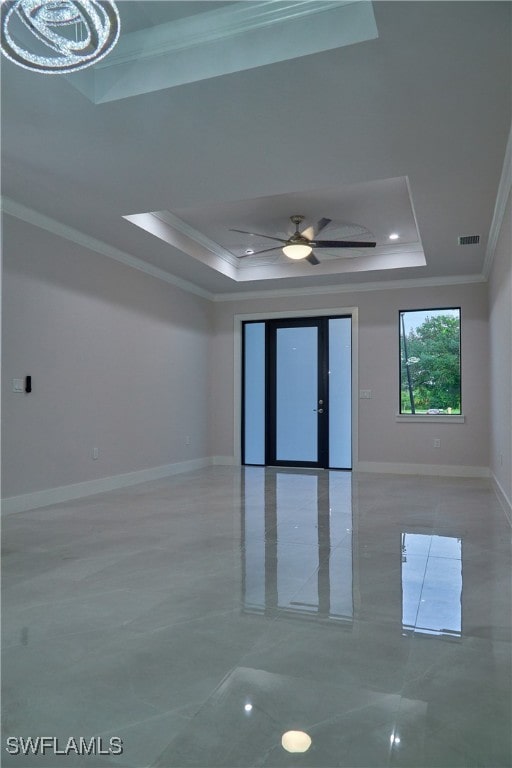 spare room with ornamental molding, a tray ceiling, and ceiling fan