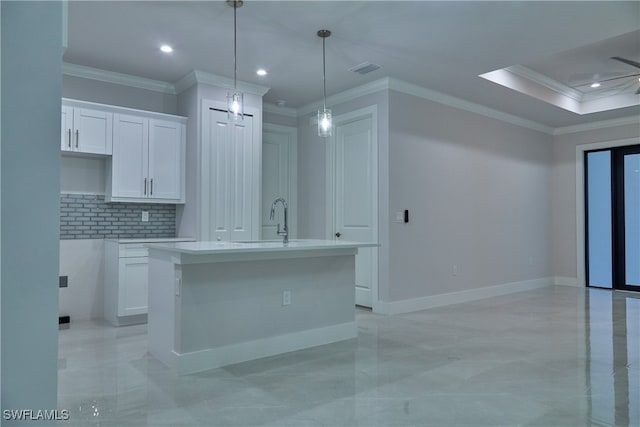 kitchen with ceiling fan, white cabinets, an island with sink, and hanging light fixtures