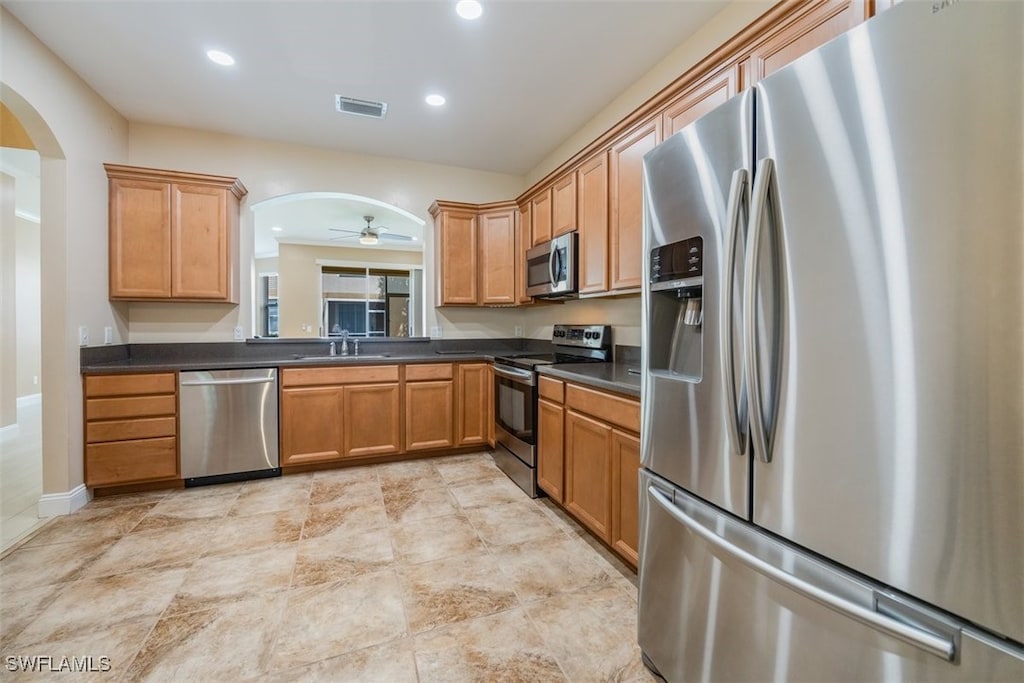 kitchen featuring appliances with stainless steel finishes, ceiling fan, and sink