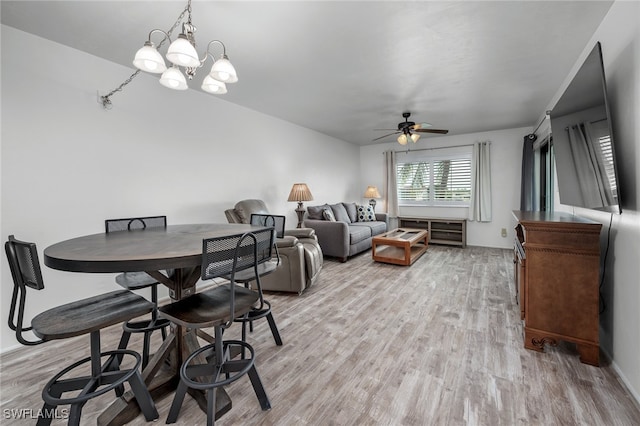 dining area featuring ceiling fan with notable chandelier and light hardwood / wood-style flooring