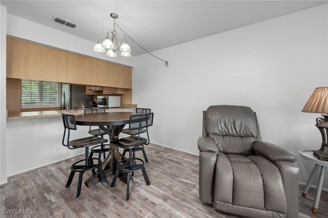 dining space with a chandelier and light hardwood / wood-style floors