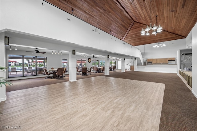 workout area featuring carpet floors, ceiling fan with notable chandelier, wood ceiling, and high vaulted ceiling