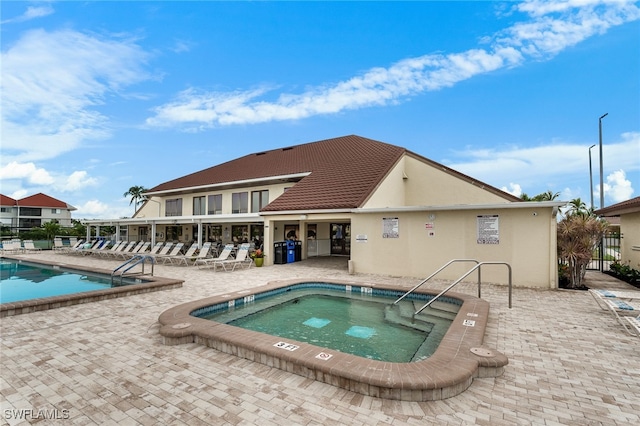 view of swimming pool with a community hot tub and a patio area