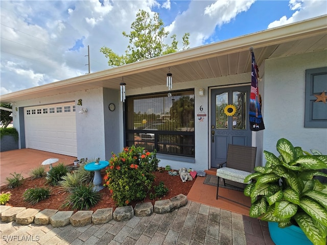 entrance to property featuring a garage and covered porch